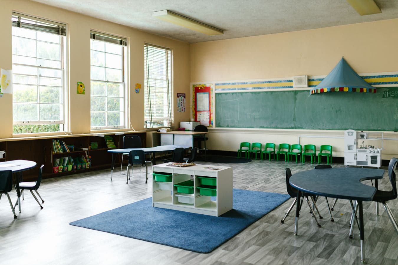 Empty preschool classroom with a play area and child-sized seating