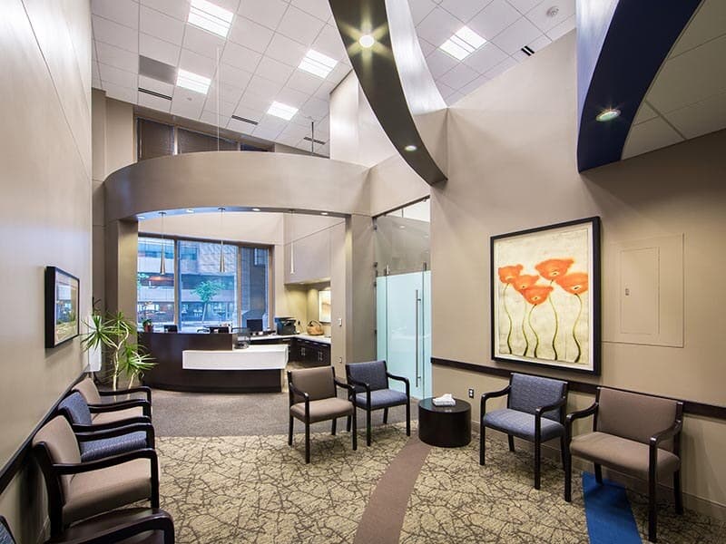 Modern medical office reception and waiting area with curved architecture and warm finishes